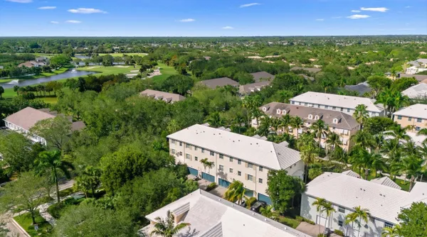 an aerial view of residential houses with outdoor space and trees