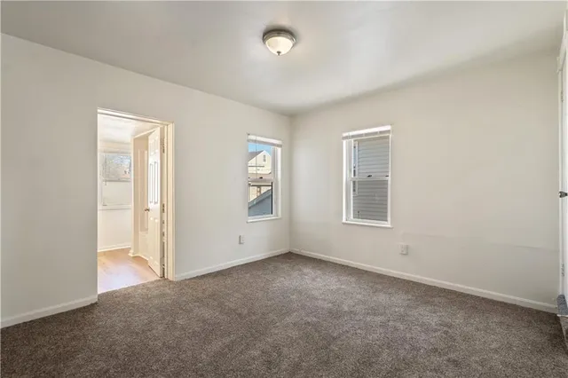 an empty room with windows and closet