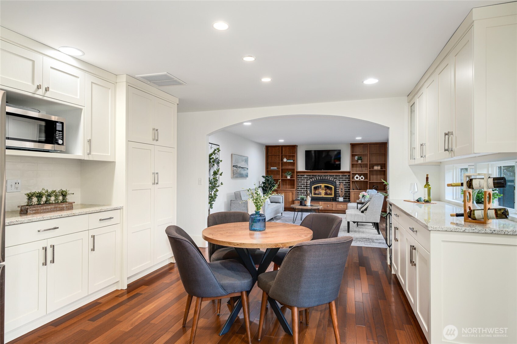 6116 152nd Avenue Northeast Redmond, WA 98052 - Photo 11 of 34 a kitchen with stainless steel appliances kitchen island granite countertop a kitchen island hardwood floor sink stove dining table and chairs