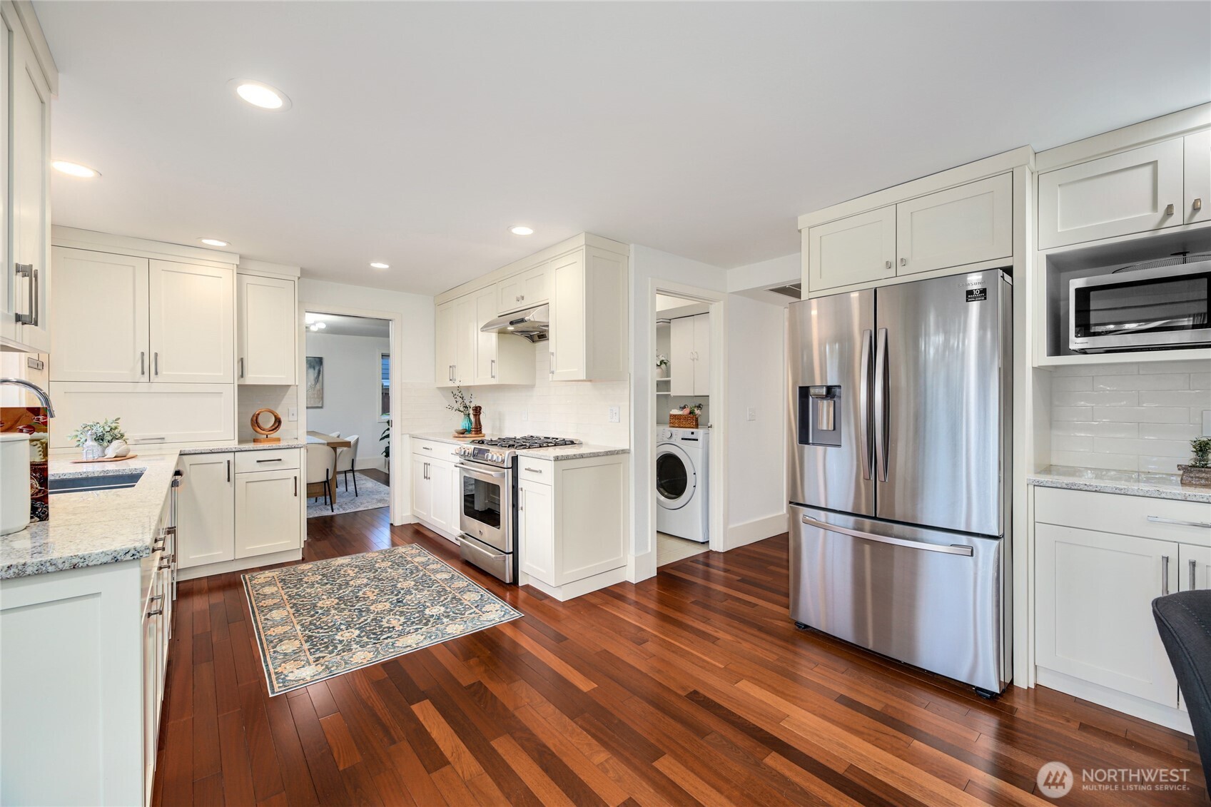 6116 152nd Avenue Northeast Redmond, WA 98052 - Photo 8 of 34 a kitchen with stainless steel appliances a refrigerator sink and wooden floor