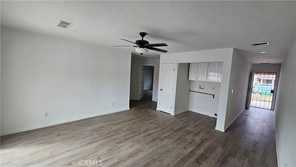 5683 Wagonwheel Road San Bernardino, CA 92407 - Photo 3 of 9 a view of a big room with wooden floor and a ceiling fan