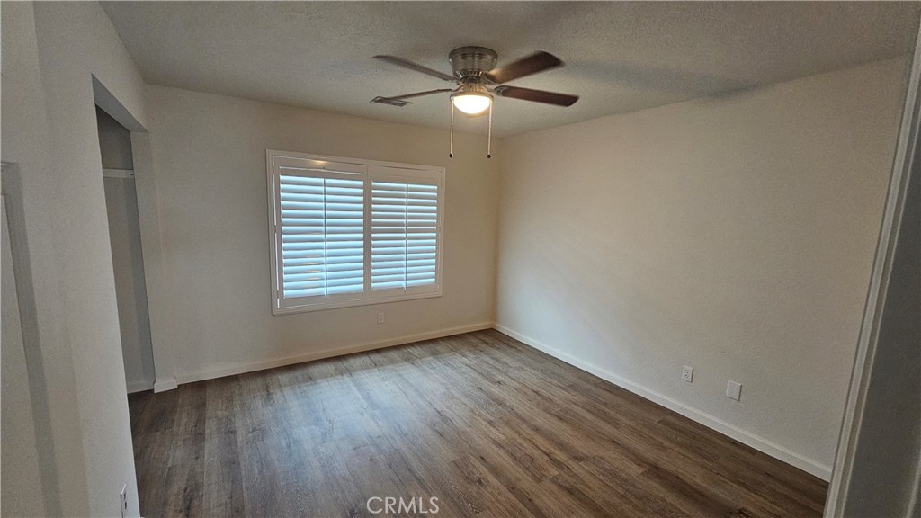 5683 Wagonwheel Road San Bernardino, CA 92407 - Photo 5 of 9 a view of an empty room with wooden floor and a window