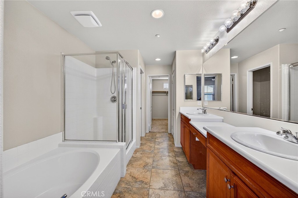 30505 Canyon Hills Road, Unit 1903 Lake Elsinore, CA 92532 - Photo 16 of 36 a large bathroom with a granite countertop double vanity sink a mirror and a bathtub
