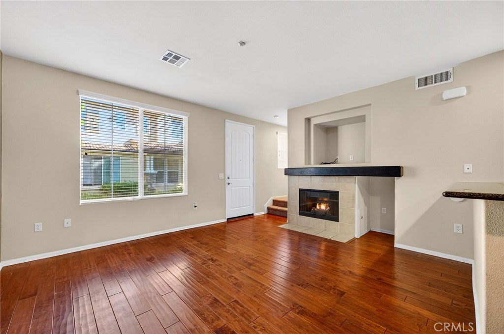 30505 Canyon Hills Road, Unit 1903 Lake Elsinore, CA 92532 - Photo 6 of 36 a view of an empty room with wooden floor fireplace and a window