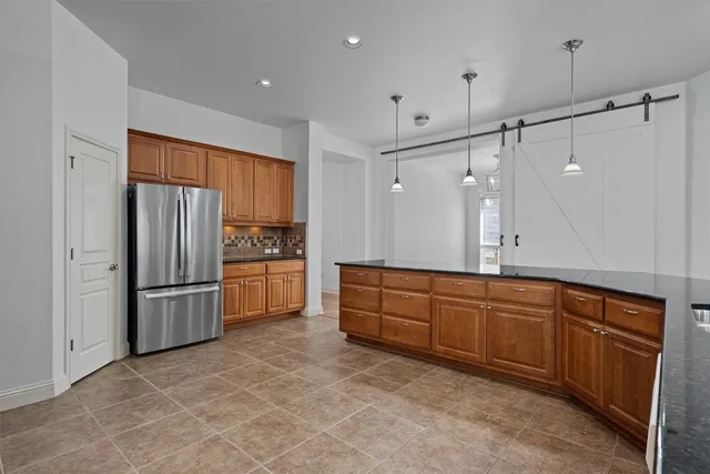 a kitchen with granite countertop a refrigerator and a sink