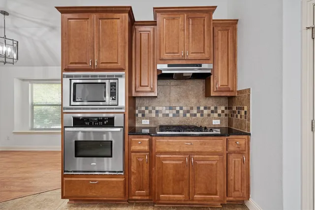 a kitchen with granite countertop cabinets stainless steel appliances and wooden cabinets