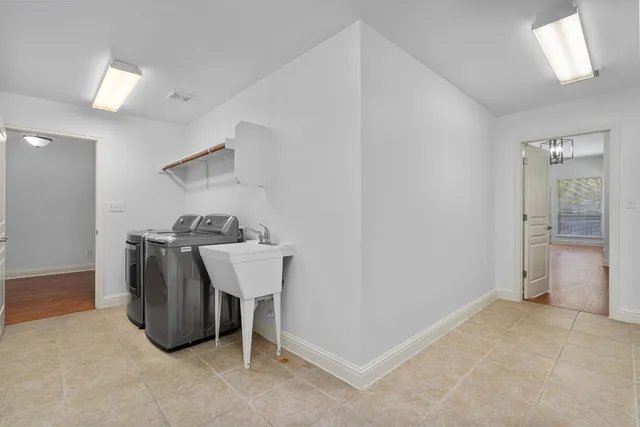 a view of cabinets with stainless steel appliances wooden floor and chair