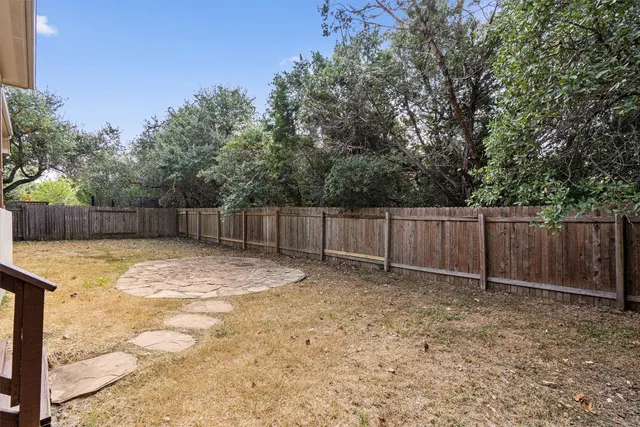 a view of a backyard with wooden fence