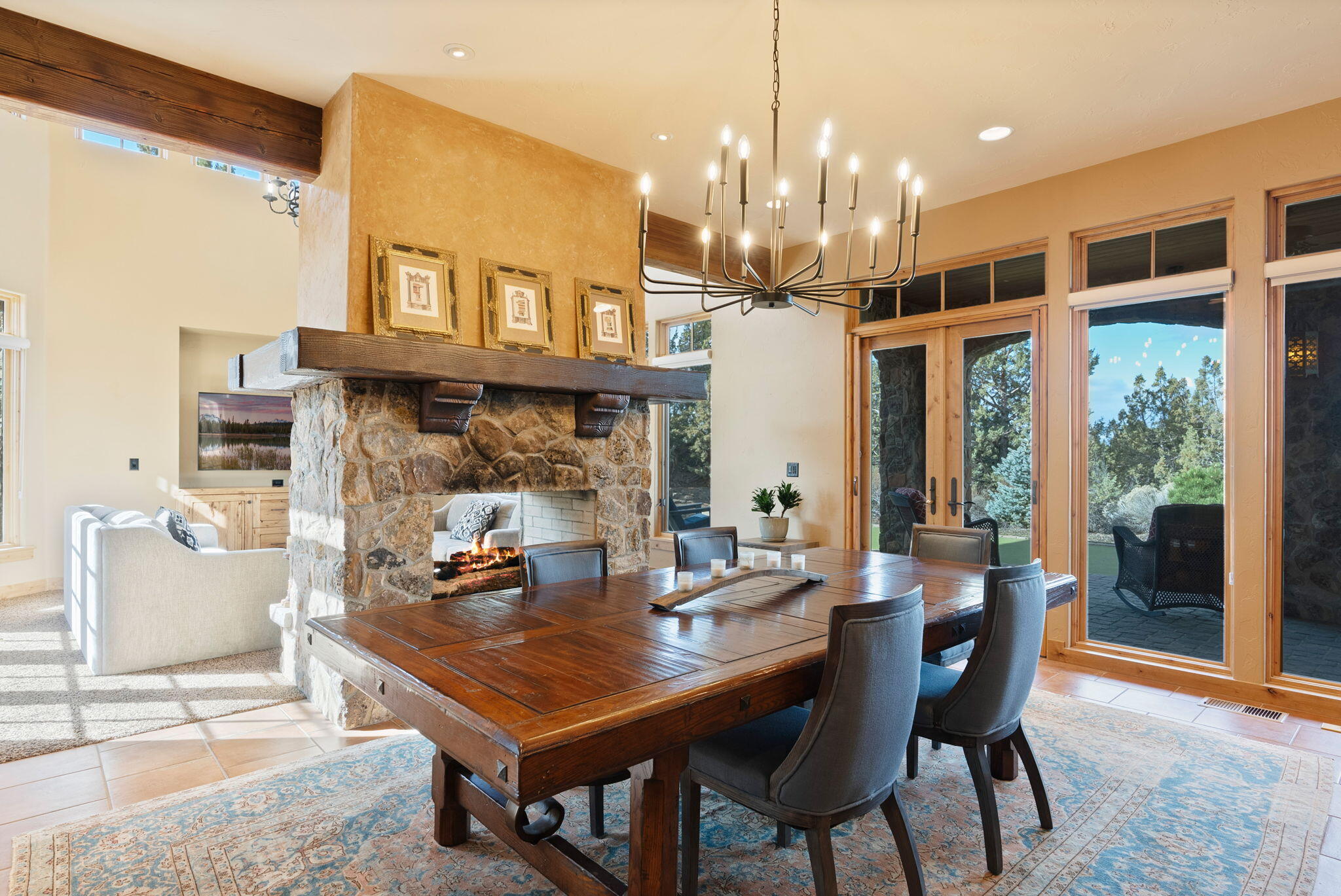 22887 Ghost Tree Lane Bend, OR 97701 - Photo 13 of 97 The light and airy dining area enjoys a beautiful double-sided natural stone fireplace creating a magical setting.