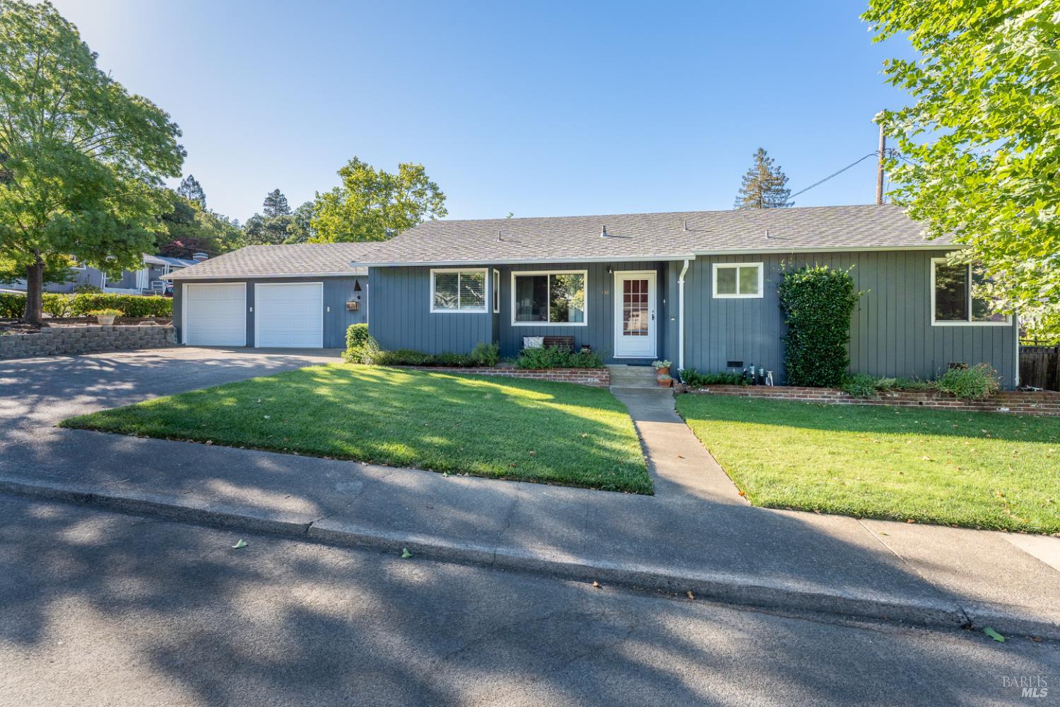 a view of a house with a yard and large tree