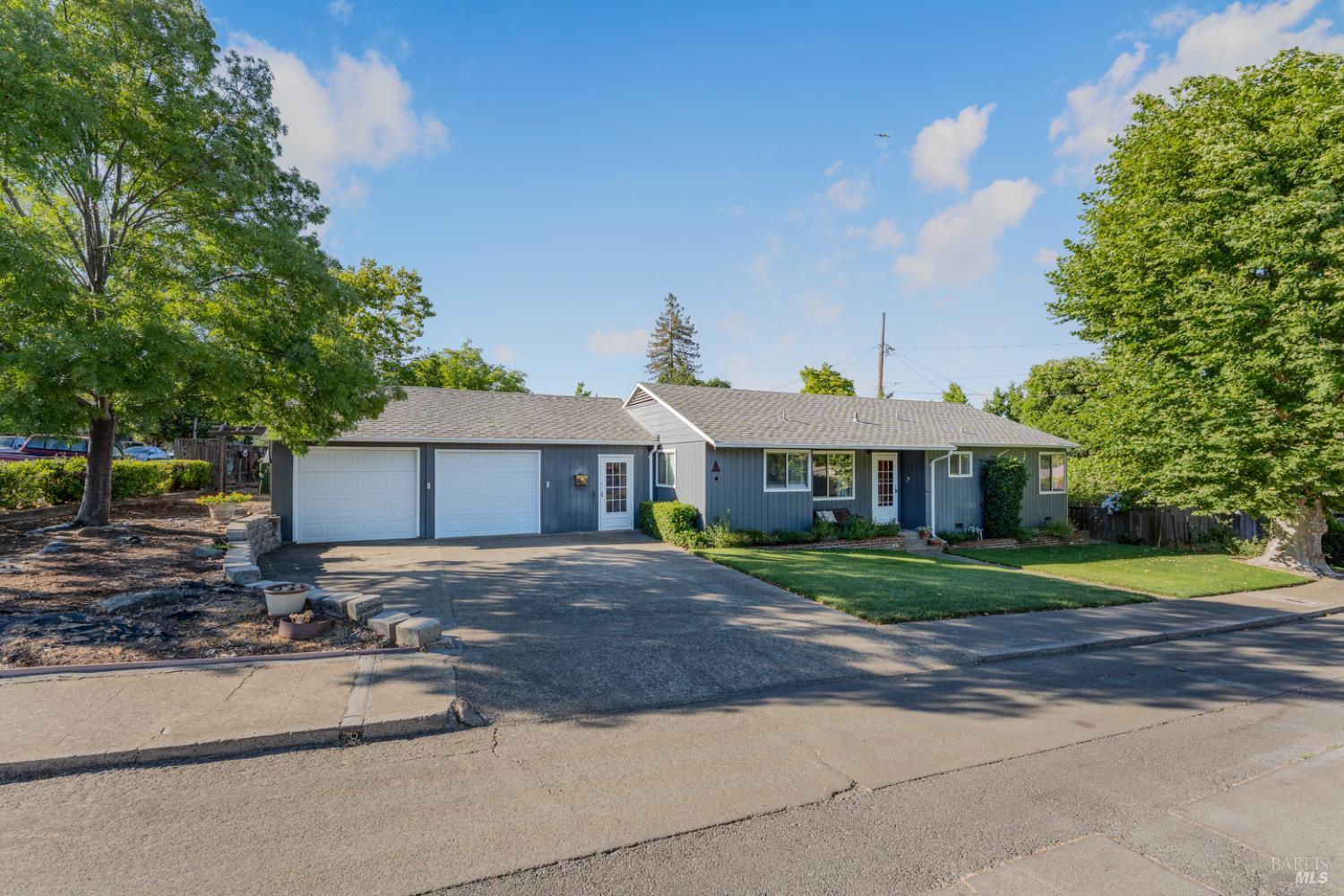 a front view of a house with a yard and trees