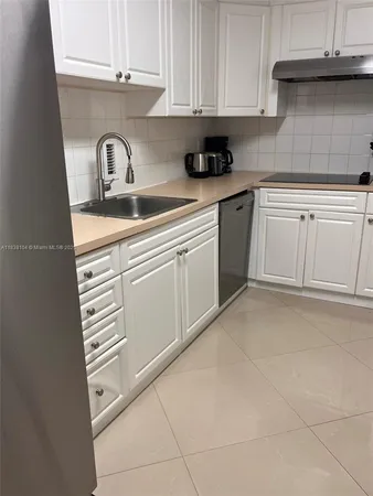 a kitchen with white cabinets and appliances