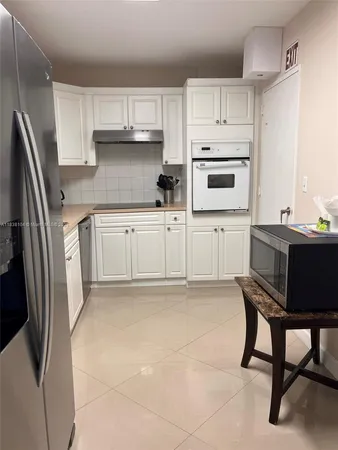 a kitchen with stainless steel appliances granite countertop a refrigerator sink and cabinets