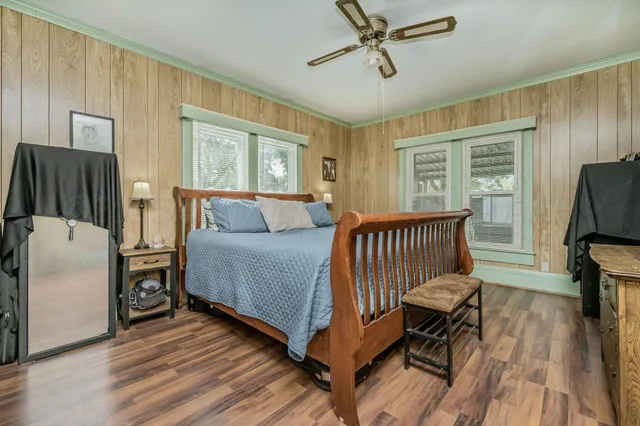 a bedroom with a bed and wooden floor