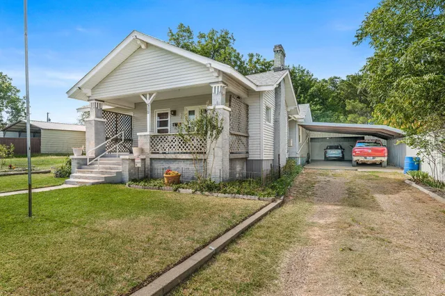 a view of a house with a yard and a garage