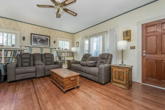 a living room with furniture a rug and a book shelf