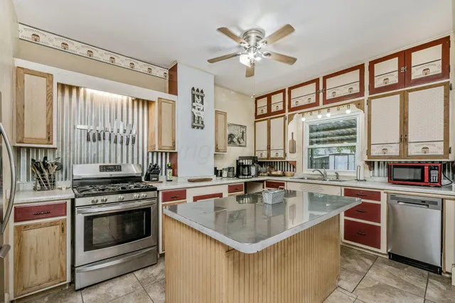 a kitchen with stainless steel appliances granite countertop a sink counter space and cabinets