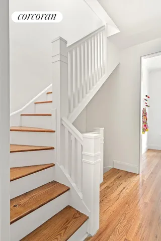 a view of a dining room with furniture a chandelier and a window