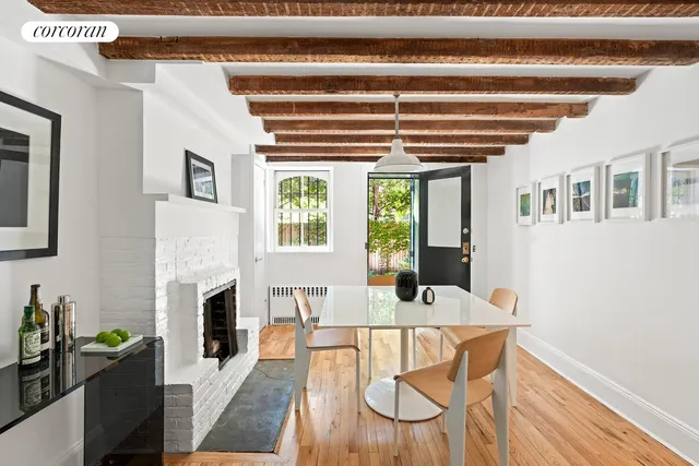 a view of a hallway with wooden floor and dining room view