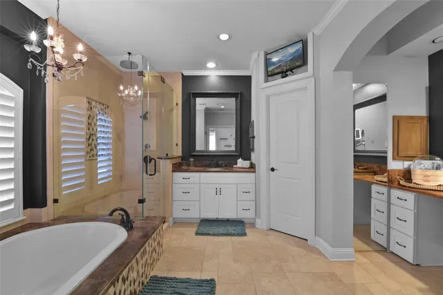 a spacious bathroom with a tub sink and mirror