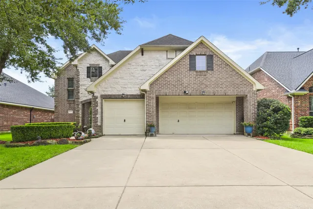 a front view of a house with a garden and garage