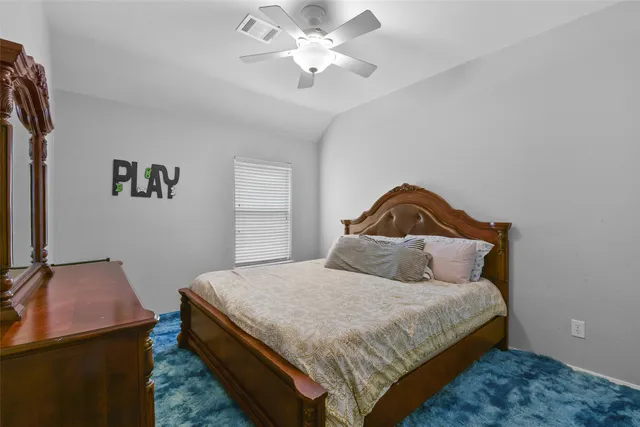 a bedroom with a bed and a ceiling fan