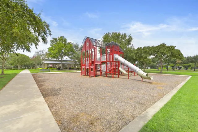 a view of a white house with a big yard and potted plants