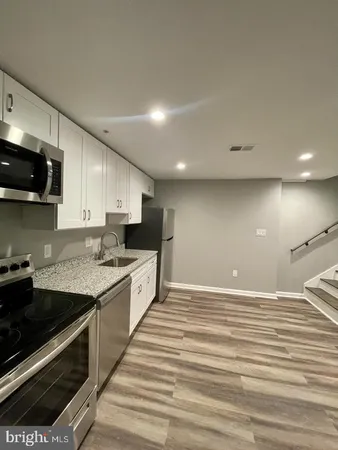 a large kitchen with granite countertop a stove and a sink
