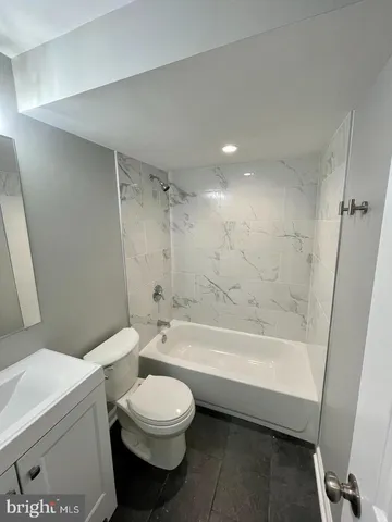 a bathroom with a toilet and a bath tub