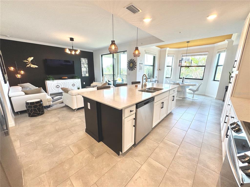 18028 Gawthrop Drive, Unit 303 Bradenton, FL 34211 - Photo 16 of 58 a large white kitchen with a large window and stainless steel appliances