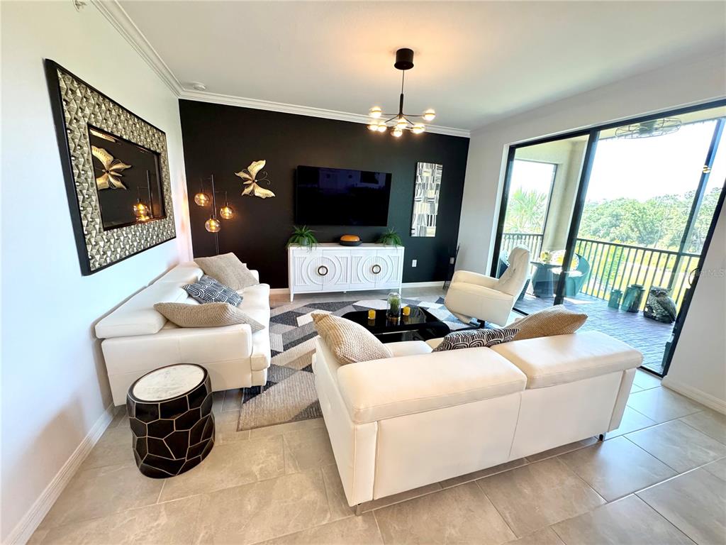 18028 Gawthrop Drive, Unit 303 Bradenton, FL 34211 - Photo 17 of 58 a living room with furniture and a flat screen tv