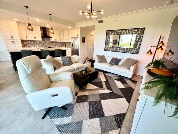 a living room with furniture and a chandelier