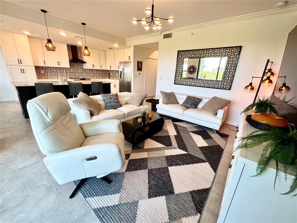 18028 Gawthrop Drive, Unit 303 Bradenton, FL 34211 - Photo 20 of 58 a living room with furniture and a chandelier