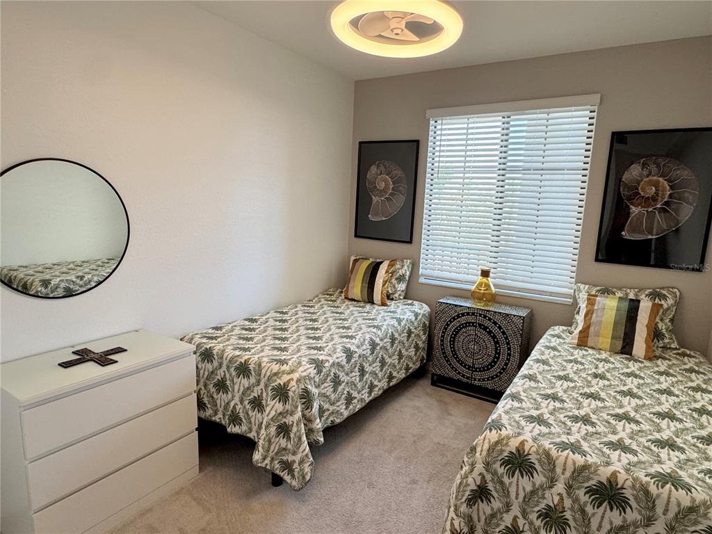 18028 Gawthrop Drive, Unit 303 Bradenton, FL 34211 - Photo 30 of 58 a bedroom with two beds and a chair