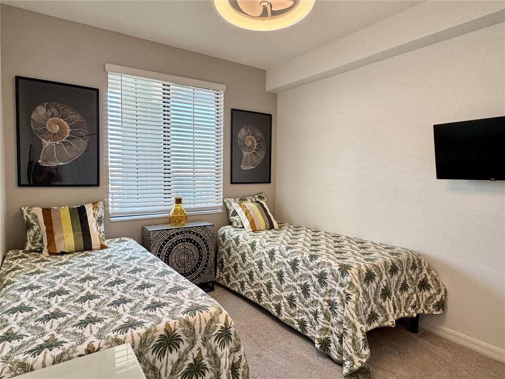 18028 Gawthrop Drive, Unit 303 Bradenton, FL 34211 - Photo 31 of 58 a bedroom with a bed and a flat screen tv