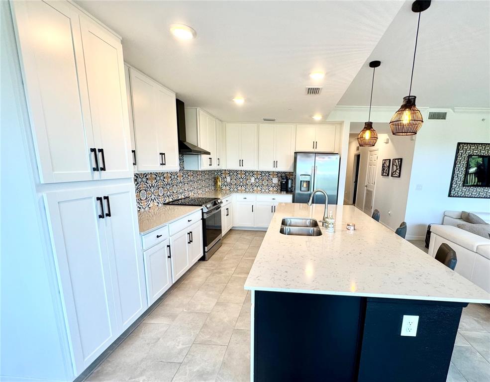 18028 Gawthrop Drive, Unit 303 Bradenton, FL 34211 - Photo 10 of 58 a kitchen with kitchen island a sink a stove a refrigerator and cabinets