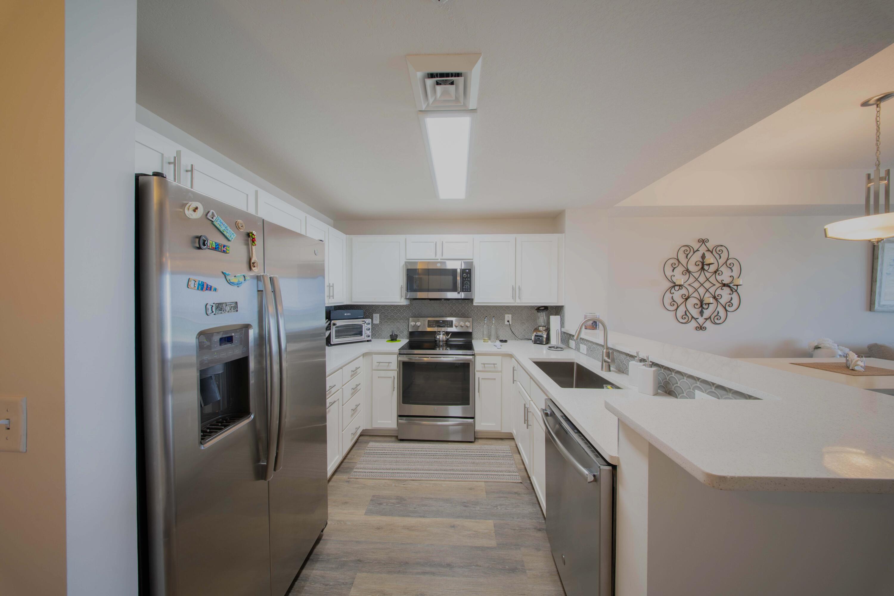 15928 Front Beach Road, Unit 32011 Panama City Beach, FL 32413 - Photo 13 of 84 a kitchen with a sink stove and refrigerator