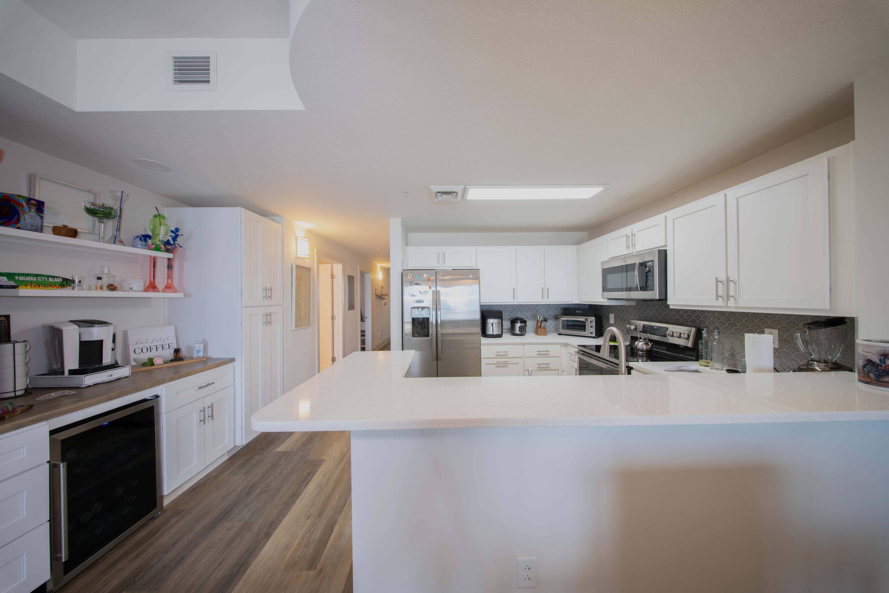 15928 Front Beach Road, Unit 32011 Panama City Beach, FL 32413 - Photo 17 of 84 a large white kitchen with cabinets
