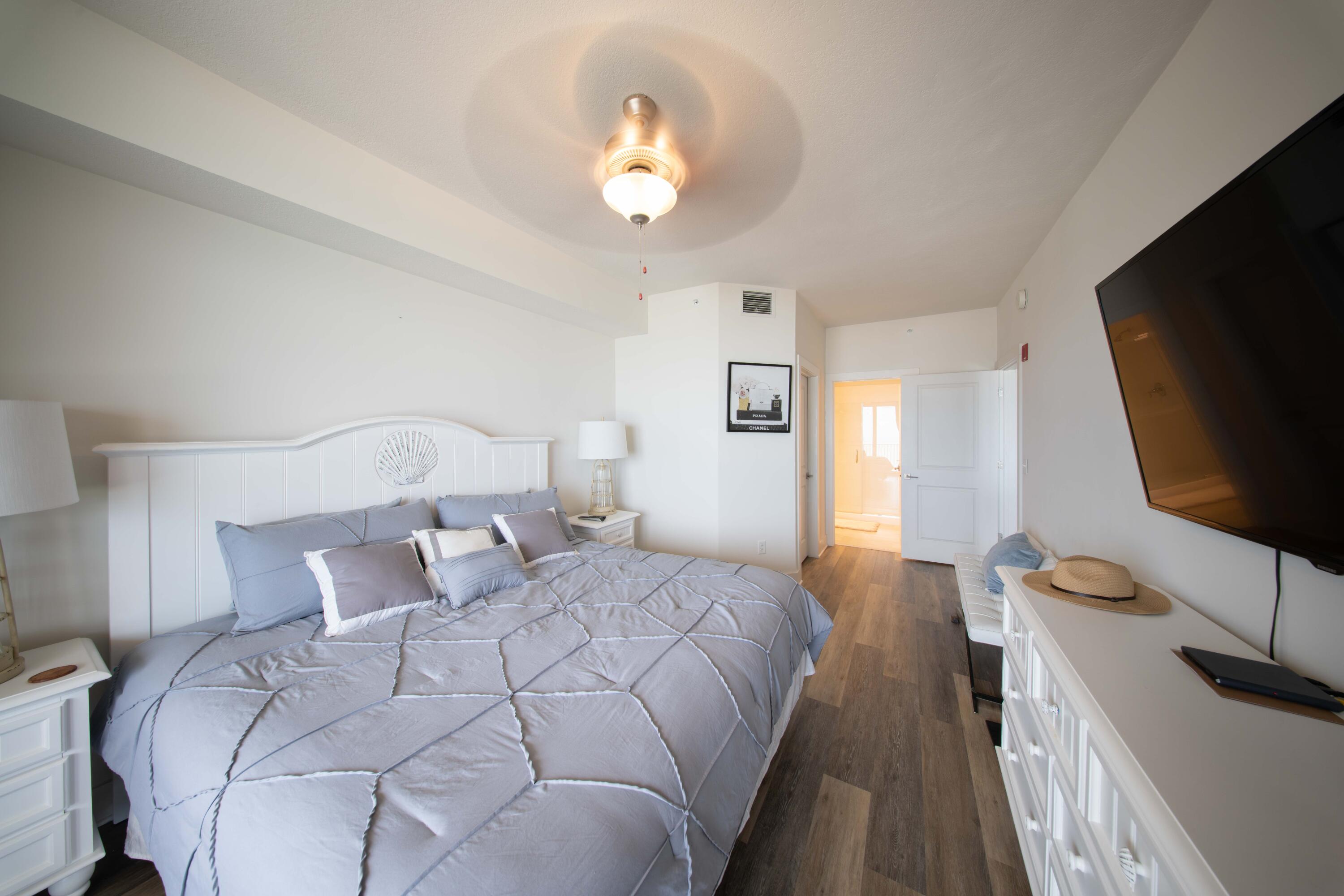 15928 Front Beach Road, Unit 32011 Panama City Beach, FL 32413 - Photo 37 of 84 a bedroom with a bed and a flat tv screen on dresser