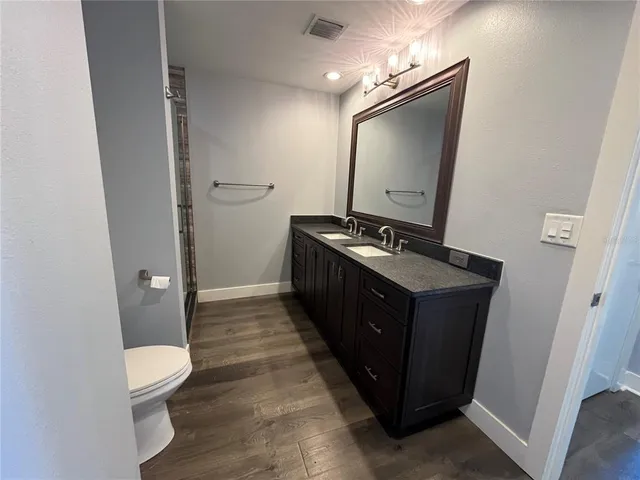 a bathroom with a toilet sink vanity and mirror