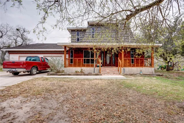 a front view of a building with large trees