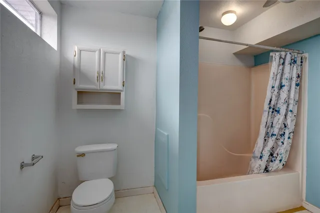 a white toilet sitting next to a bathroom sink and vanity