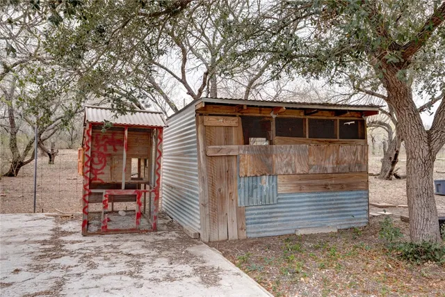 a view of a house with a yard and large tree