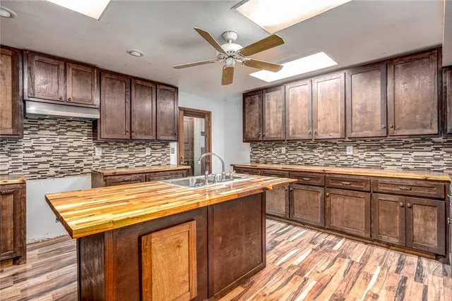 a kitchen with stainless steel appliances granite countertop a sink a stove counter space and cabinets