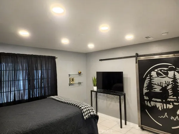 a bedroom with a bed and a television