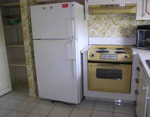 9915 Sandalfoot Boulevard, Unit 419 Boca Raton, FL 33428 - Photo 2 of 5 a stove top oven sitting inside of a kitchen