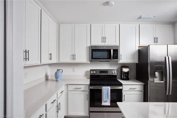 a kitchen with white cabinets and stainless steel appliances