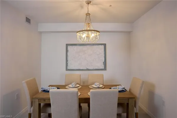 a view of a dining room with furniture and a chandelier