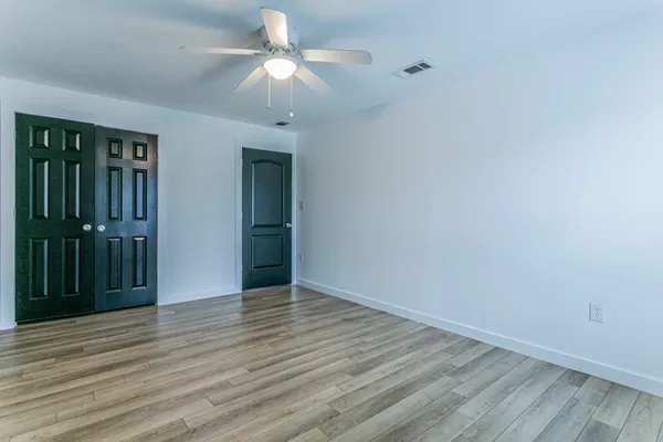 a view of an empty room with wooden floor