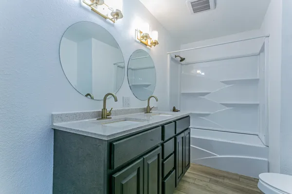 a bathroom with a sink and mirror with toilet